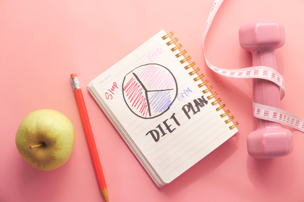 Diet Plan with Almond Nut, Dumbbells, Apple on Table